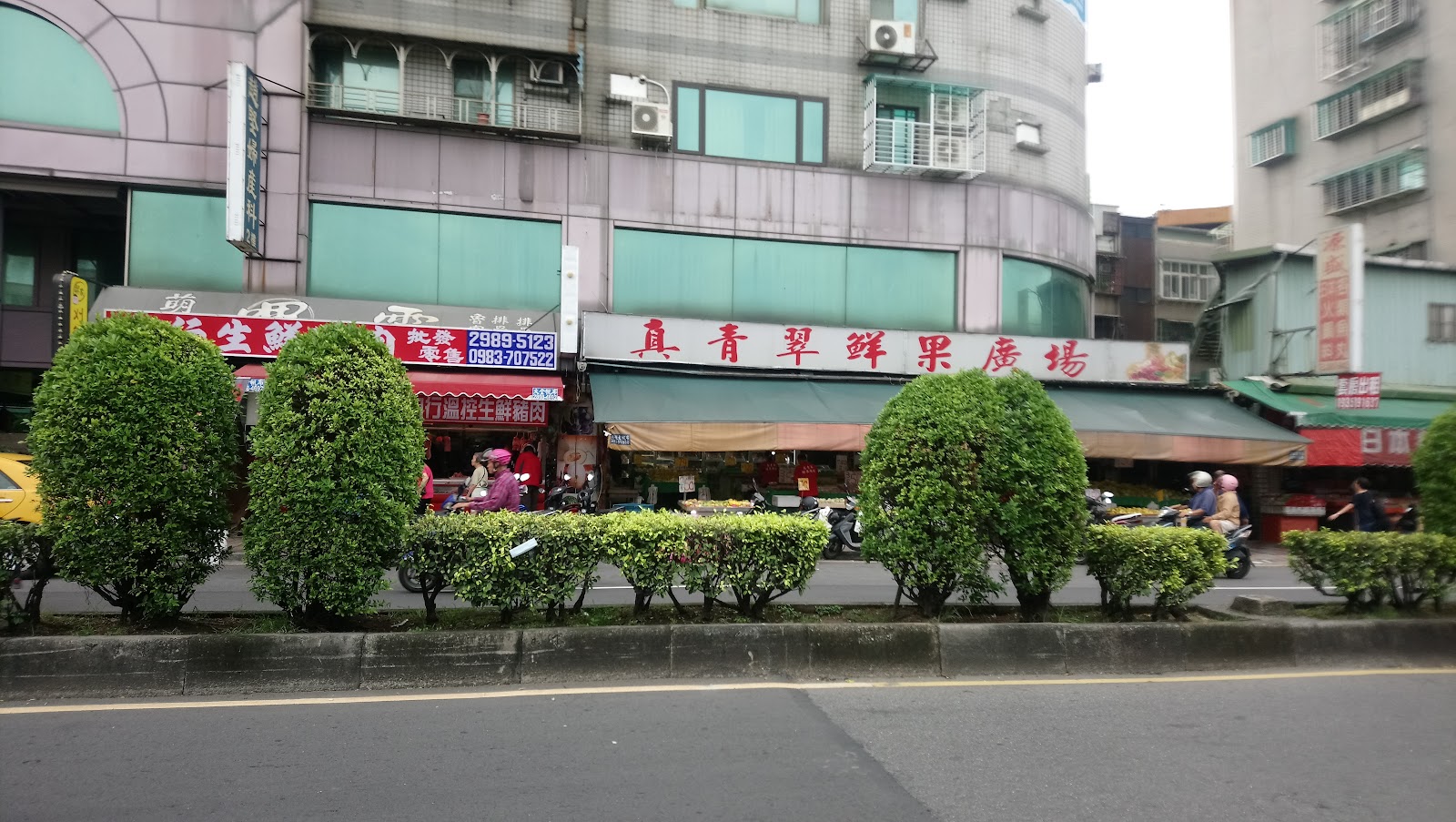 三重力行菜市場臨街入口,真青翠鮮果廣場招牌醒目,路邊行道樹修剪整齊