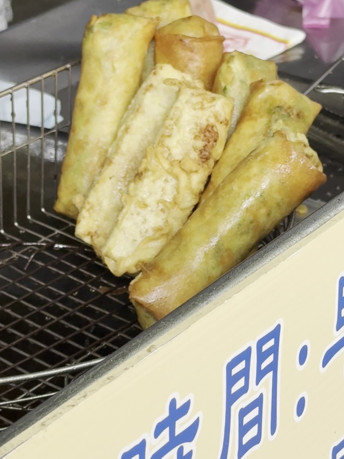 三星阿琴春捲油炸架上金黃春捲特寫
