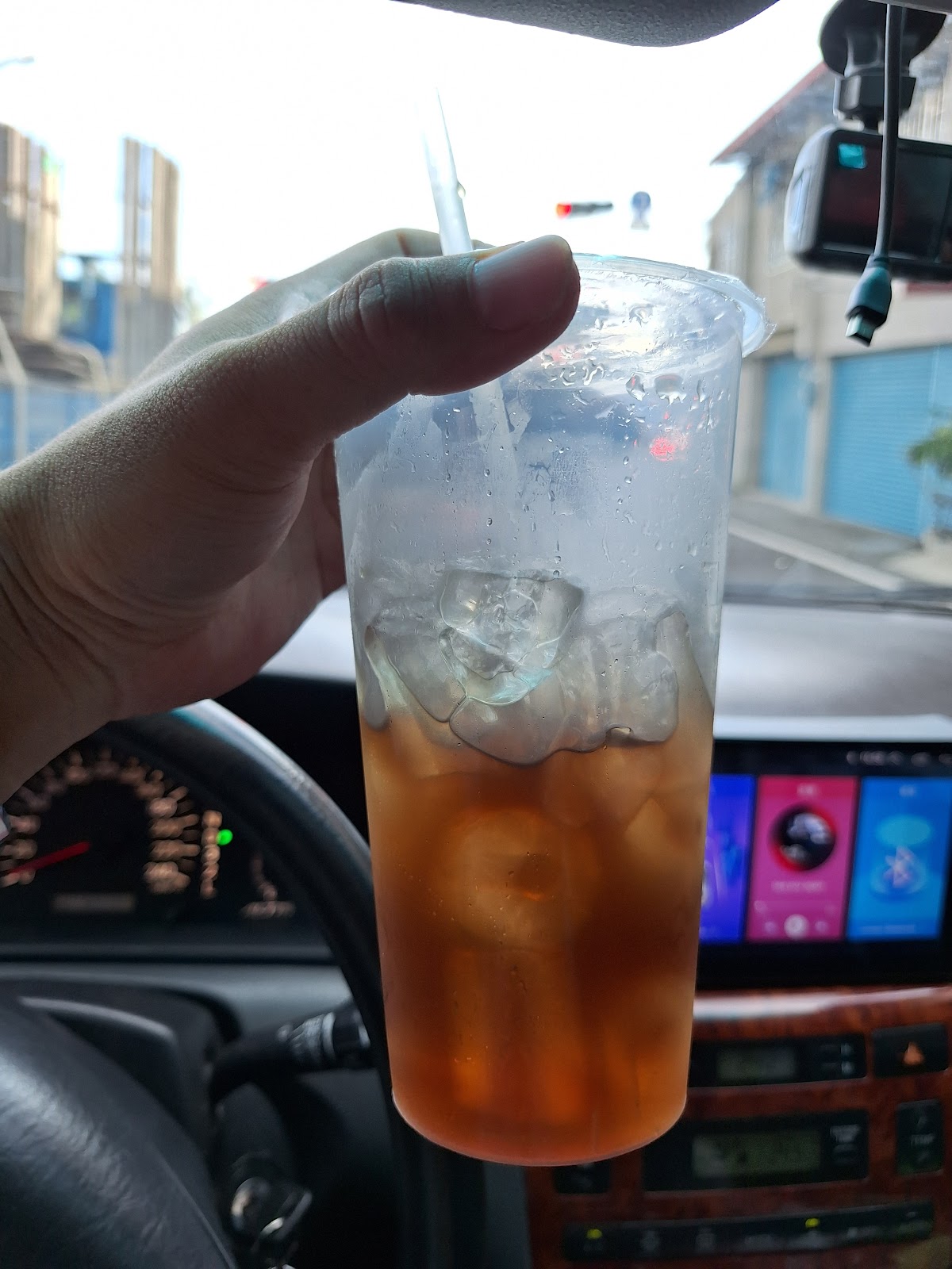 手持冬瓜茶杯，車內儀表板背景