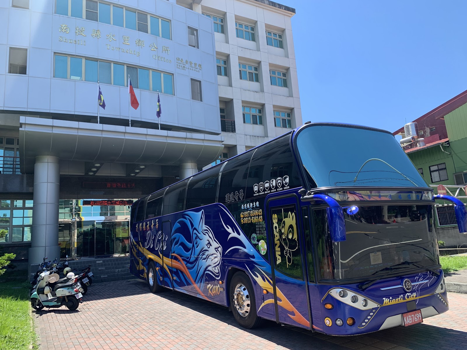 一台遊覽車停靠在南投縣水里鄉公所門口,建築全貌清晰可見