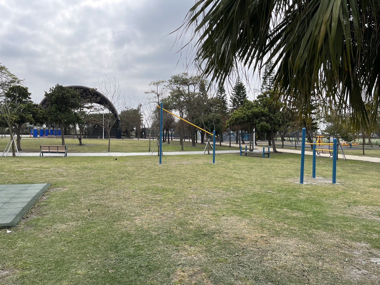 四湖鄉運動公園的草地廣場，戶外健身器材與遠方半月形遮棚