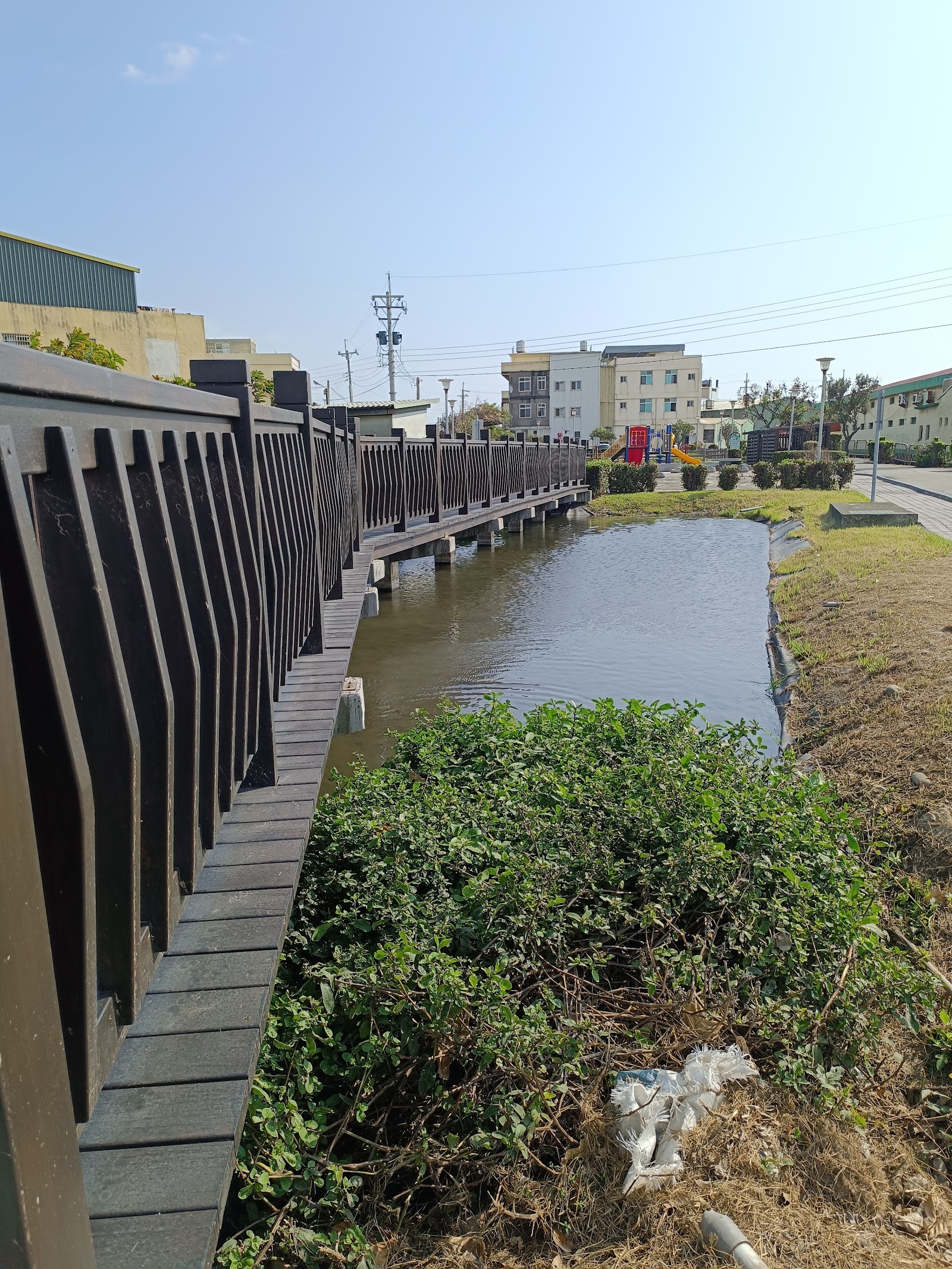定順園生態公園木棧道護欄沿小水圳延伸遠方兒童遊戲場