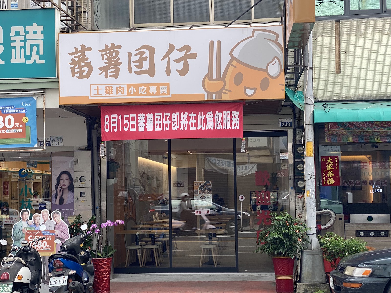 蕃薯囝仔店面招牌外觀，橘色吉祥物招牌搭配玻璃落地窗