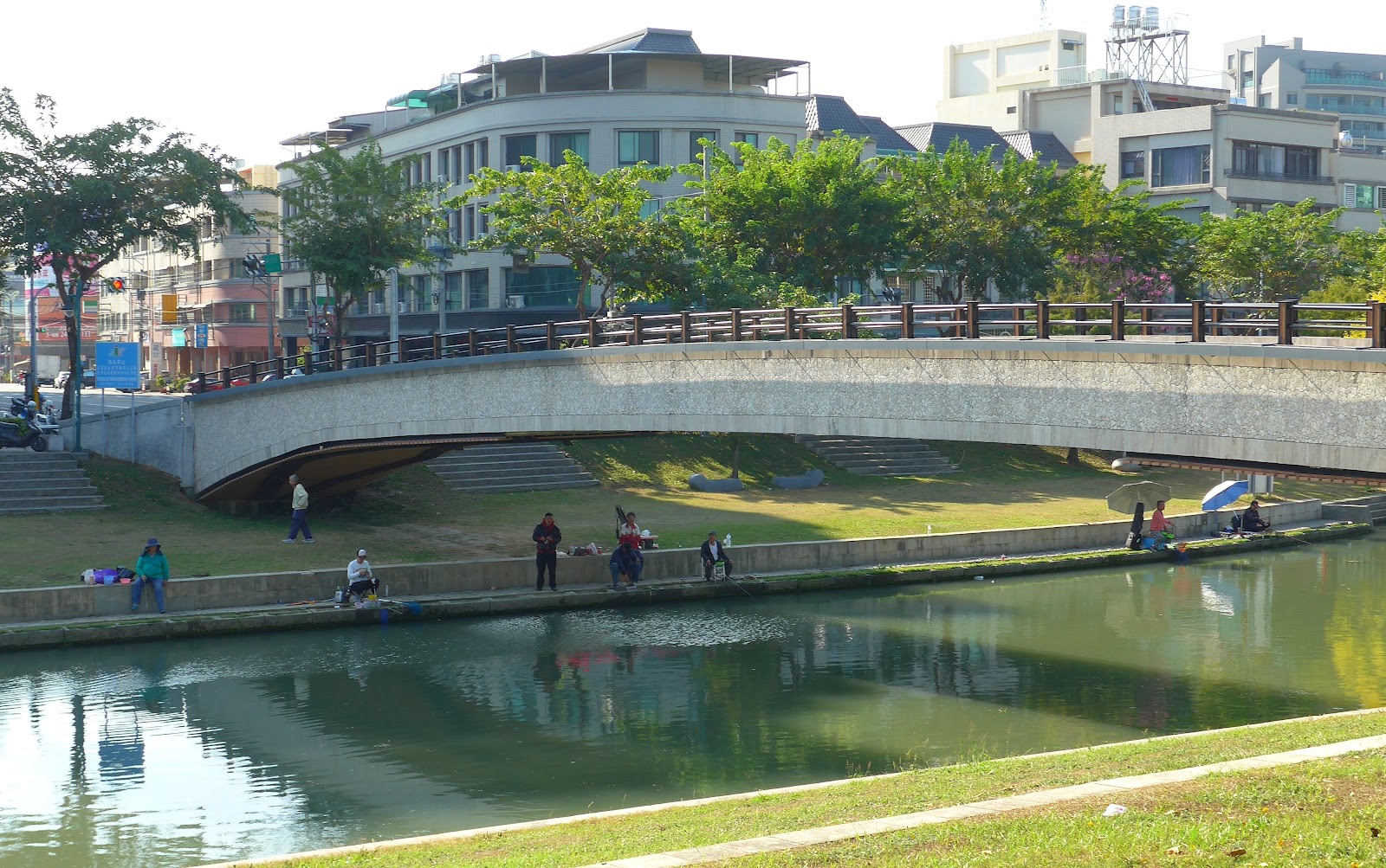 興大康橋橋體全景，橋下河岸不時有釣客垂釣身影
