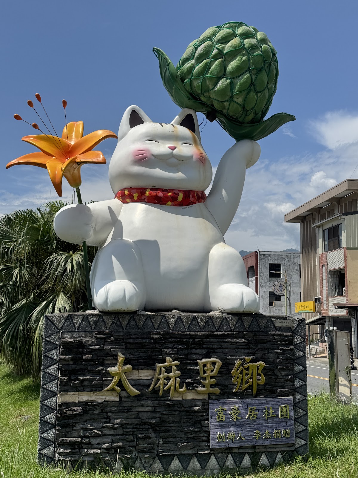 太麻里地標招財貓正面 太麻里鄉地標招財貓裝置藝術正面,左手持金針花右手舉釋迦
