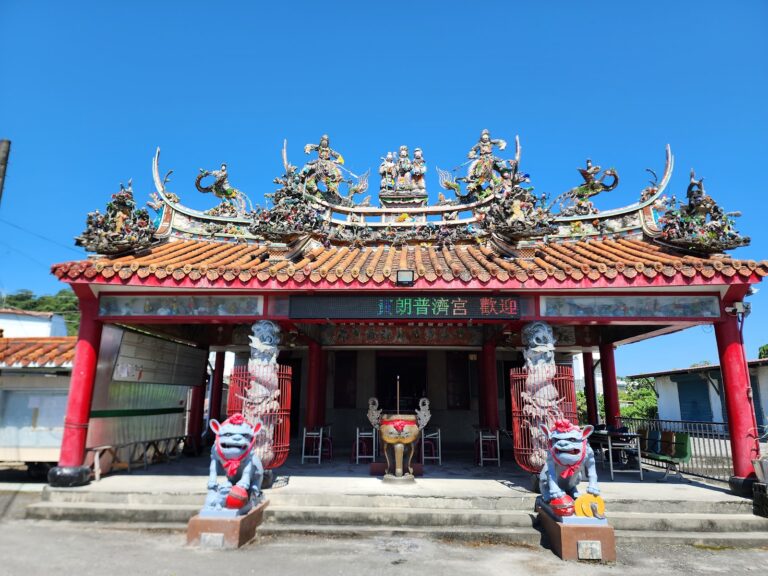 卑南賓朗普濟宮廟宇正面全景,石獅與交趾陶屋脊剪黏,藍天襯托