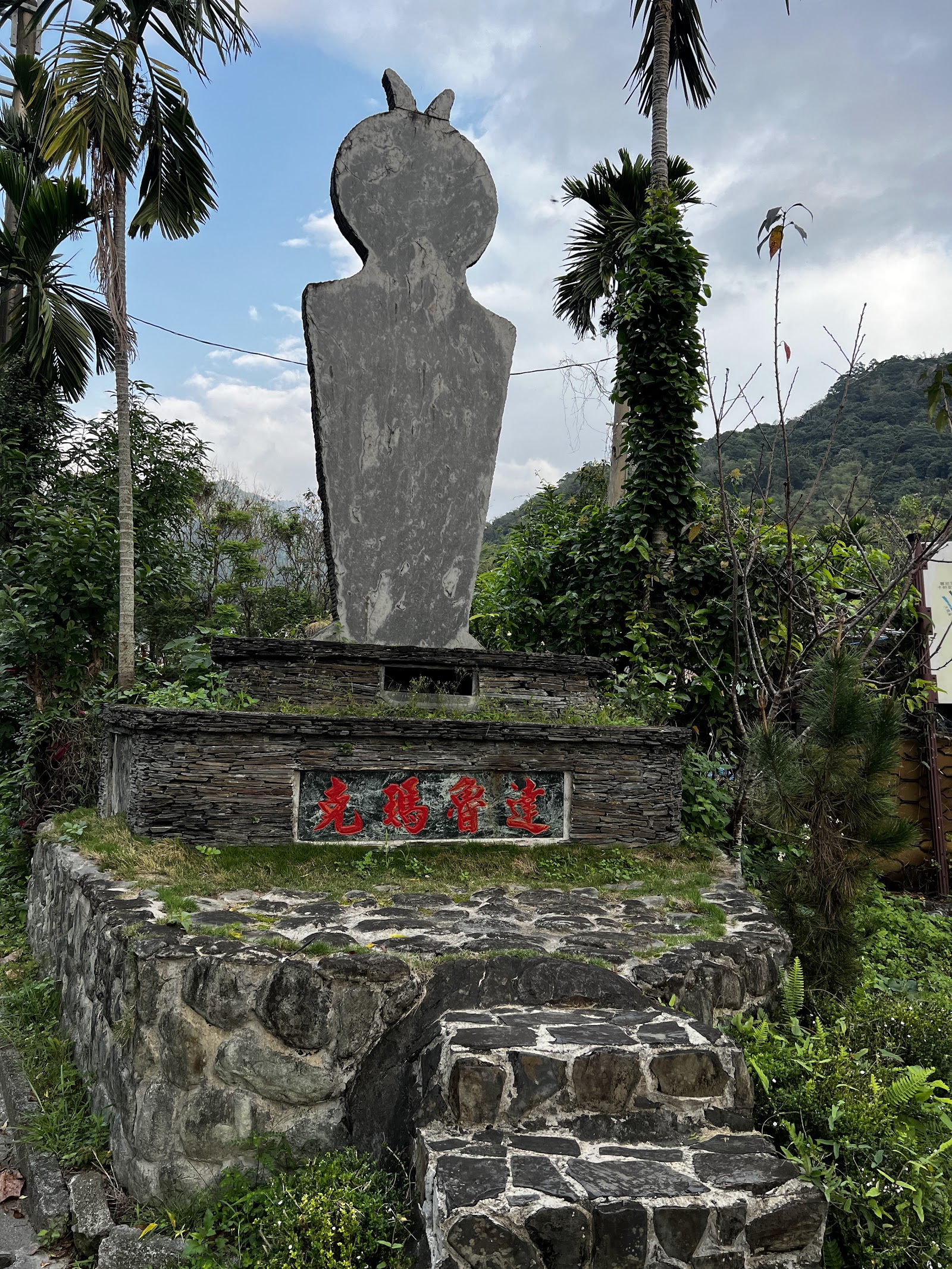 台東縣卑南鄉東興村入口意象石碑，背景山巒與聚落街景