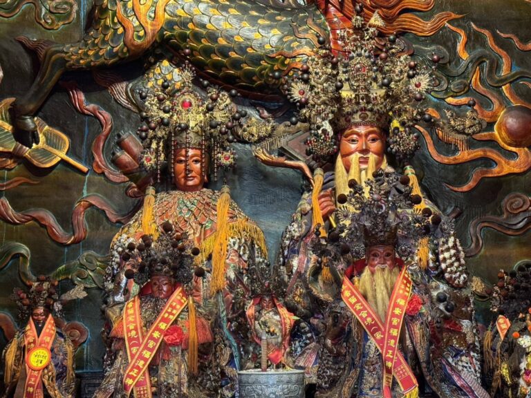 福德正神與夫人神像特寫，身披信眾獻贈綬帶，神像雕工精細