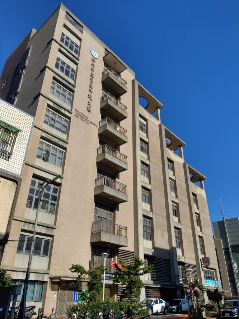 萬里區公所側面藍天照，外牆可見英文「Wanli District Administration Building」標示