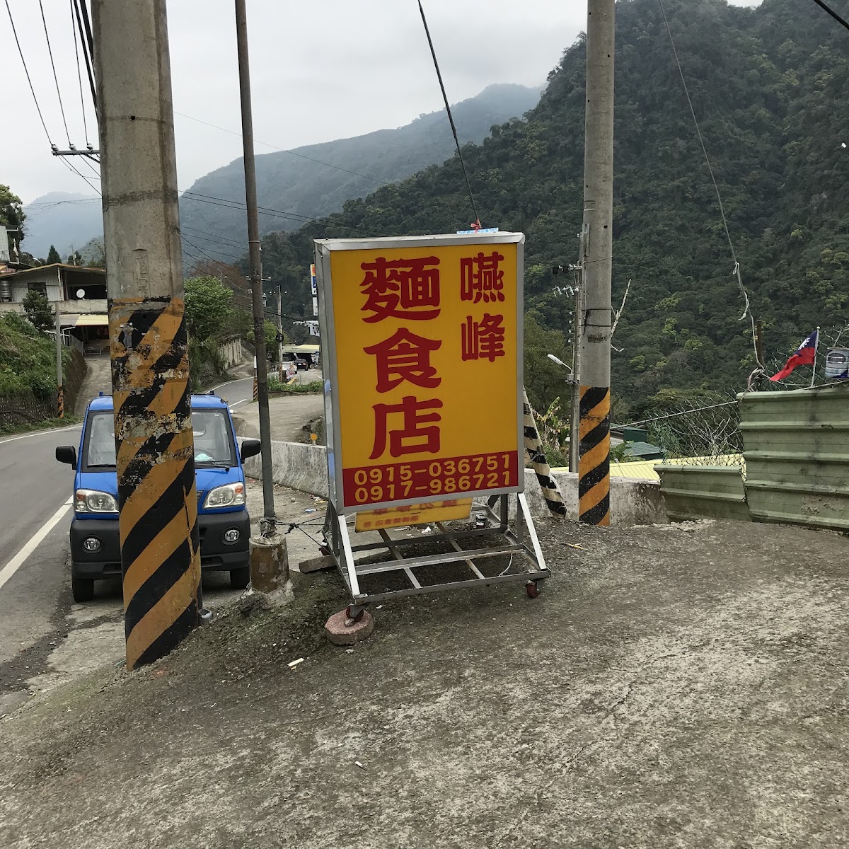 嚥峰麵食店路邊招牌，黃底紅字與電話號碼