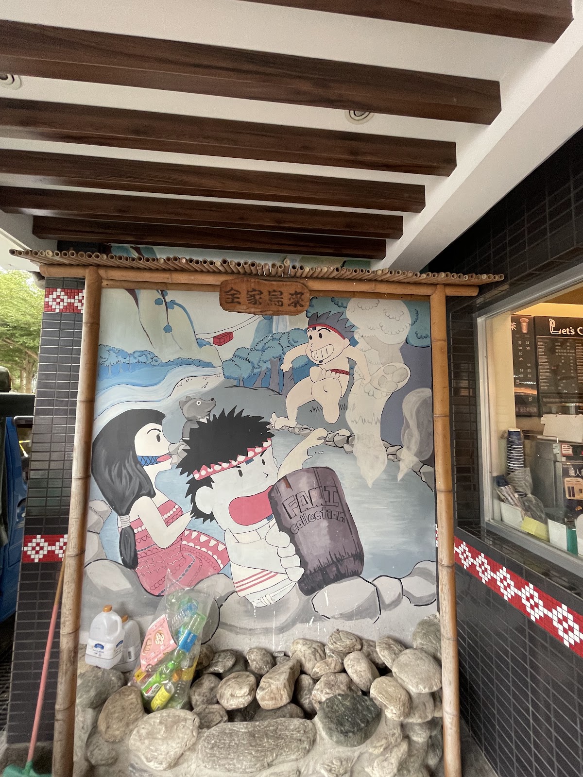 全家便利商店烏來店門口竹編看板上的泰雅族風格彩繪壁畫