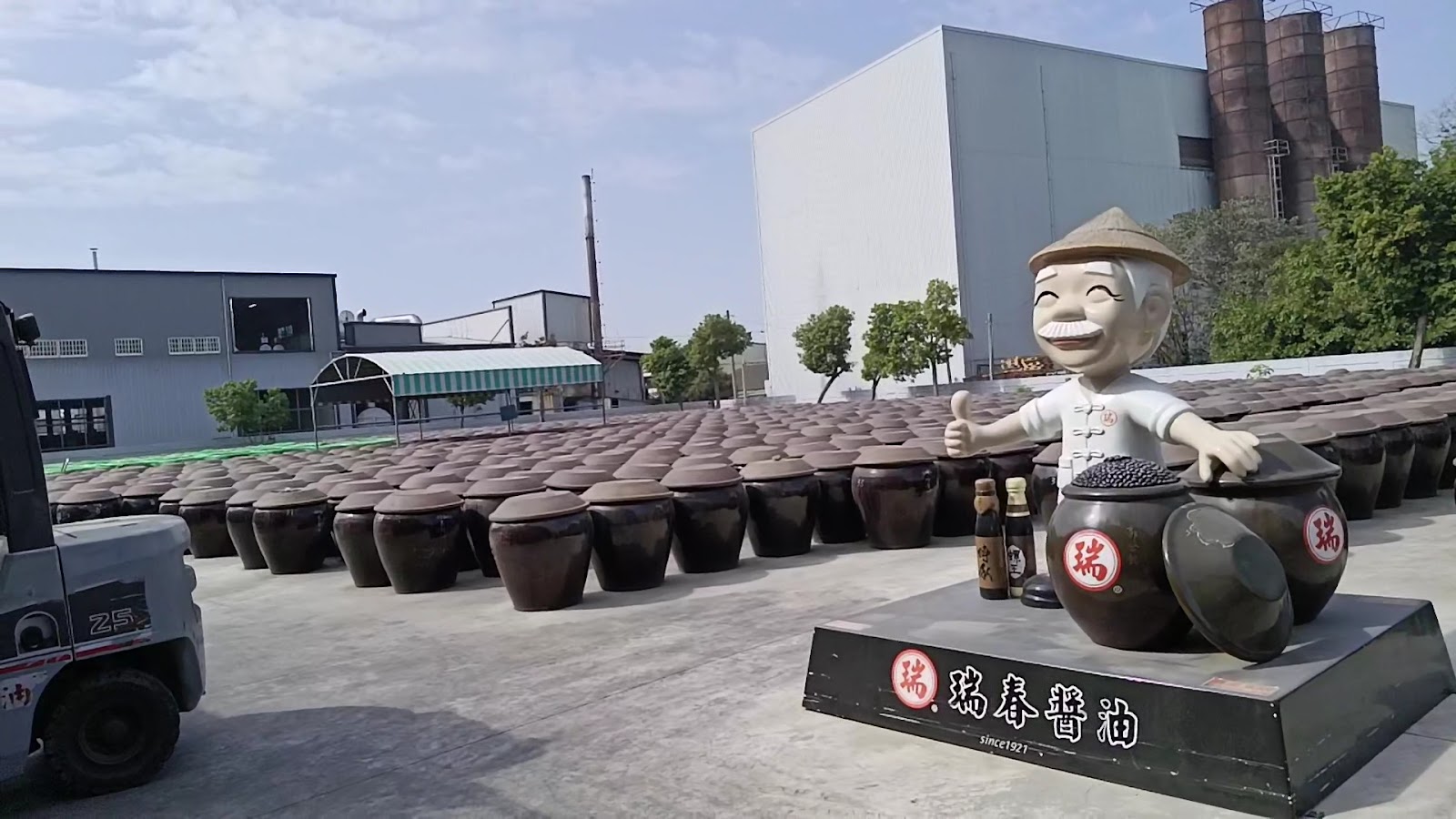 瑞春醬油觀光工廠甕場另一角度，含堆高機與遠景穀倉