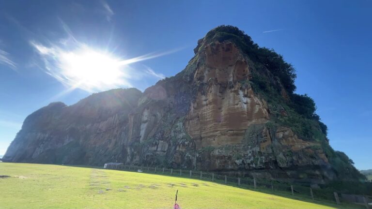 番仔澳酋長岩公園酋長岩側臉岩壁與藍天草地全景