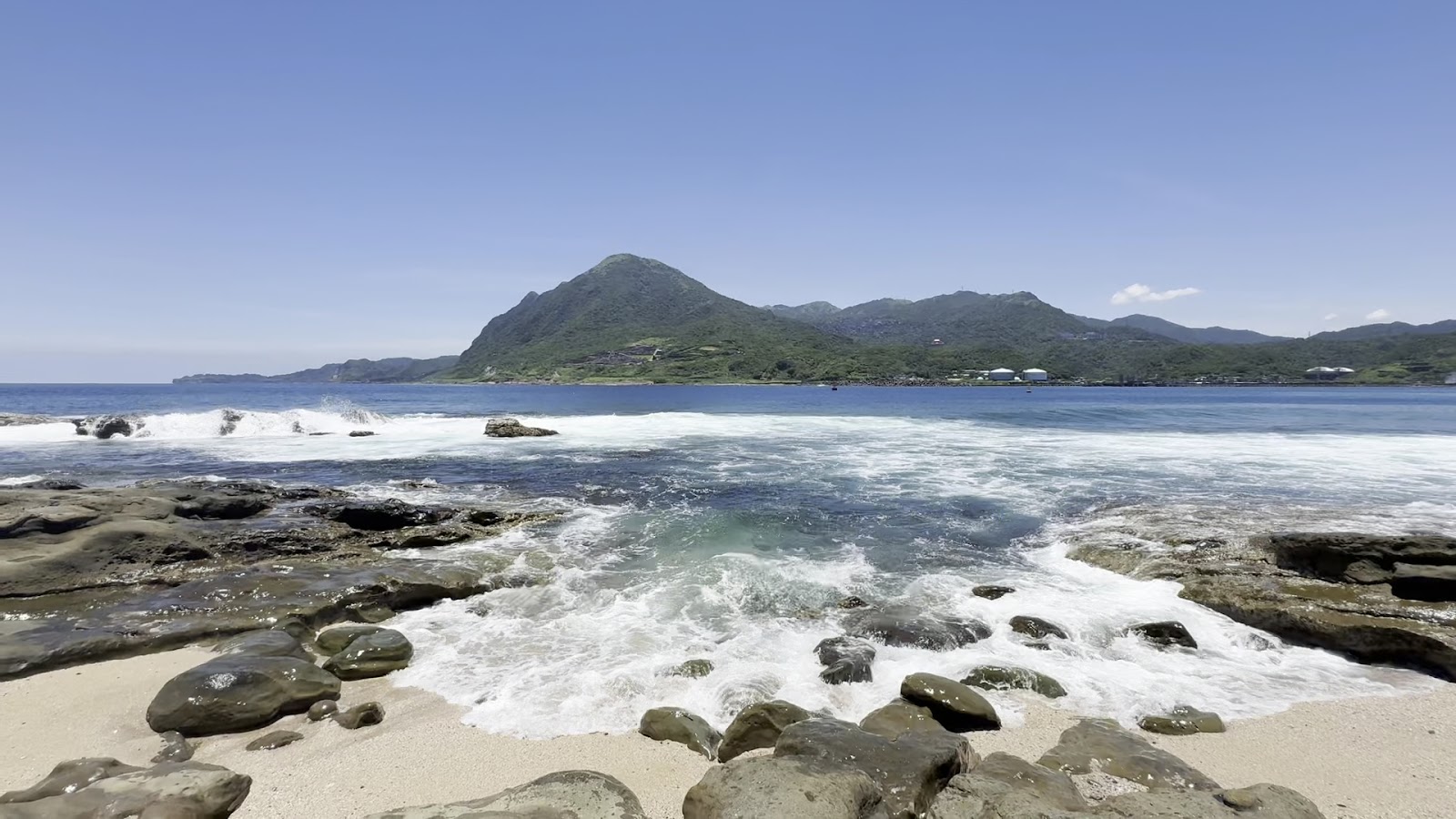 番仔澳海岸礁岩浪花與基隆山稜線