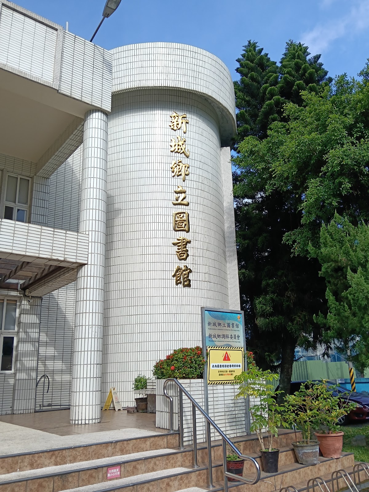 新城鄉立圖書館建築外觀,圓柱白色磁磚建築與直式招牌