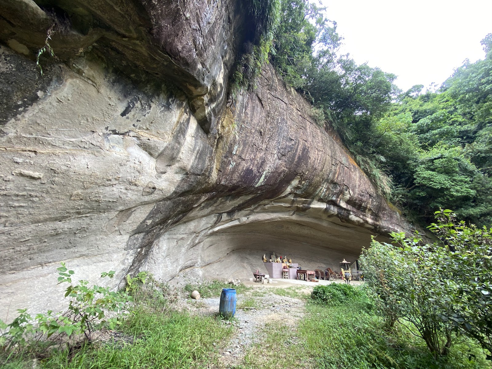 泰山巖廟址嵌於天然岩石洞穴內,可見神桌供品與岩壁紋理