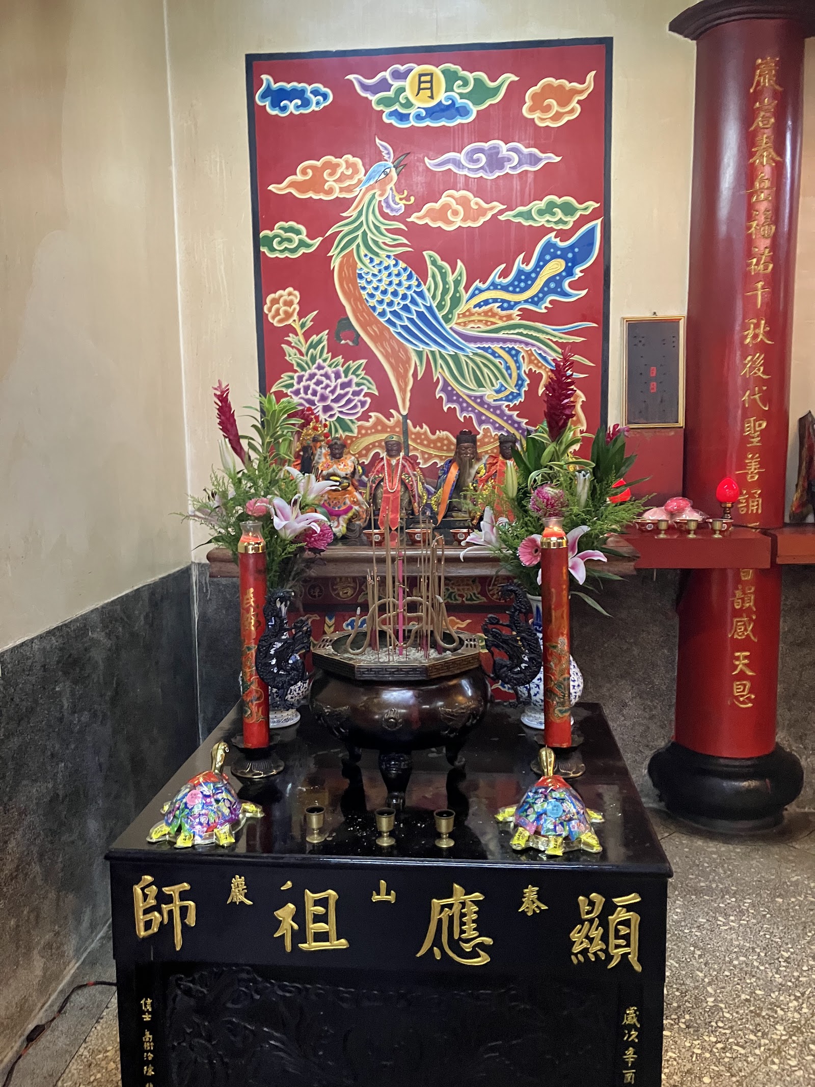 泰山巖神龕「顯應祖師」字樣特寫,鳳凰彩繪背板與香爐鮮花