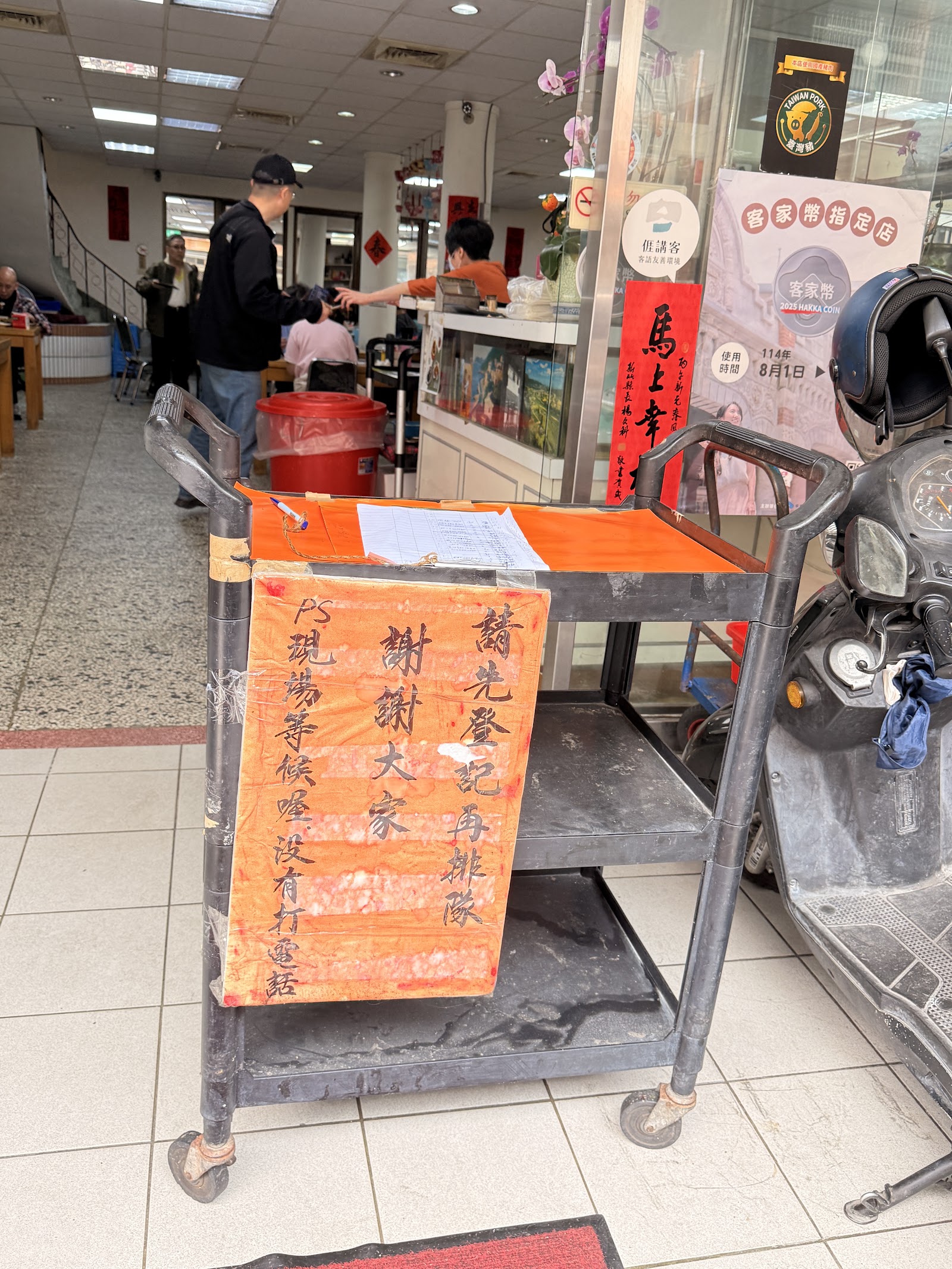新竹日勝飲食店店內等候號碼牌推車，橘色手寫告示牌