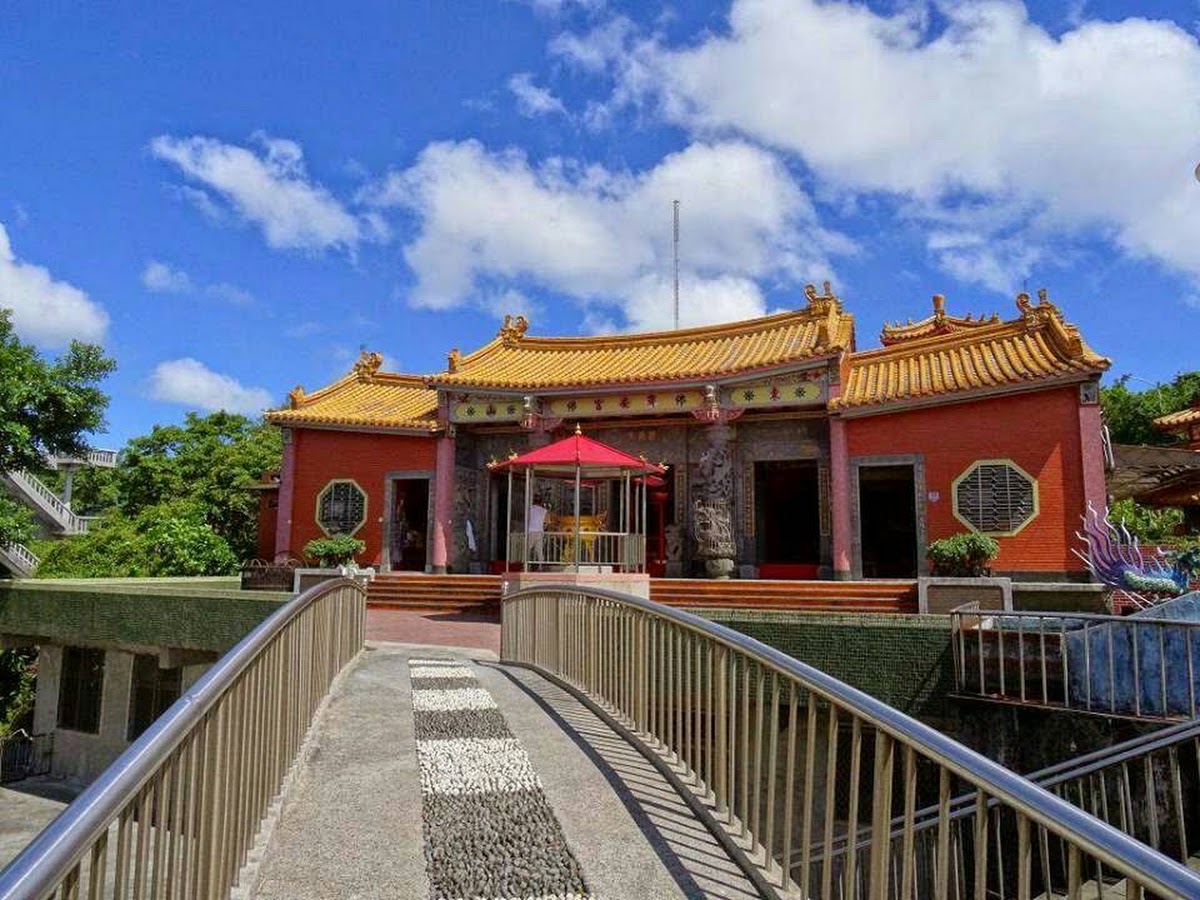 基隆濟安宮廟埕正面全景，金黃琉璃瓦屋頂與朱紅廟身，橋前步道