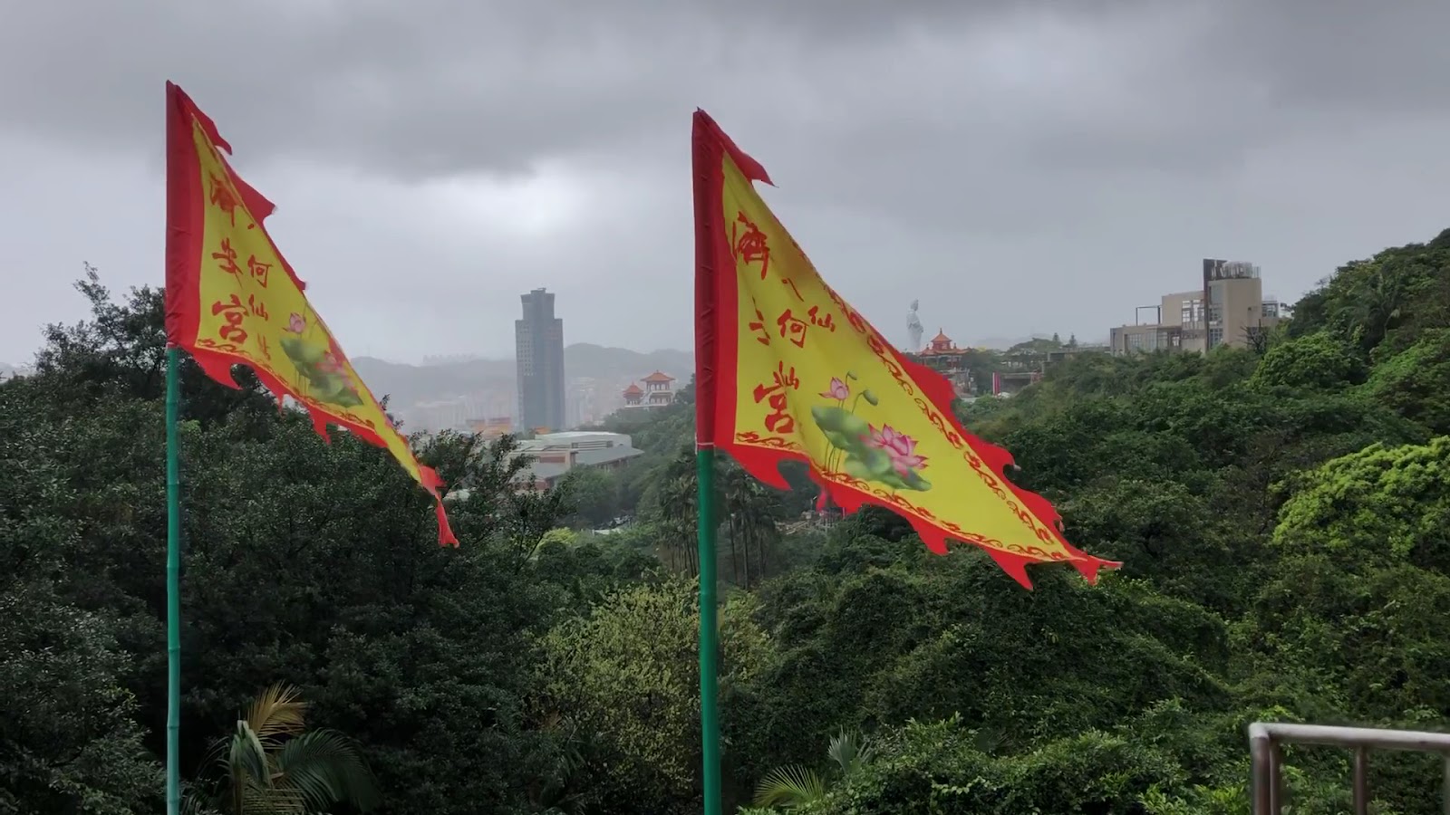 濟安宮廟前何仙姑繡旗迎風飄揚,遠眺基隆市區