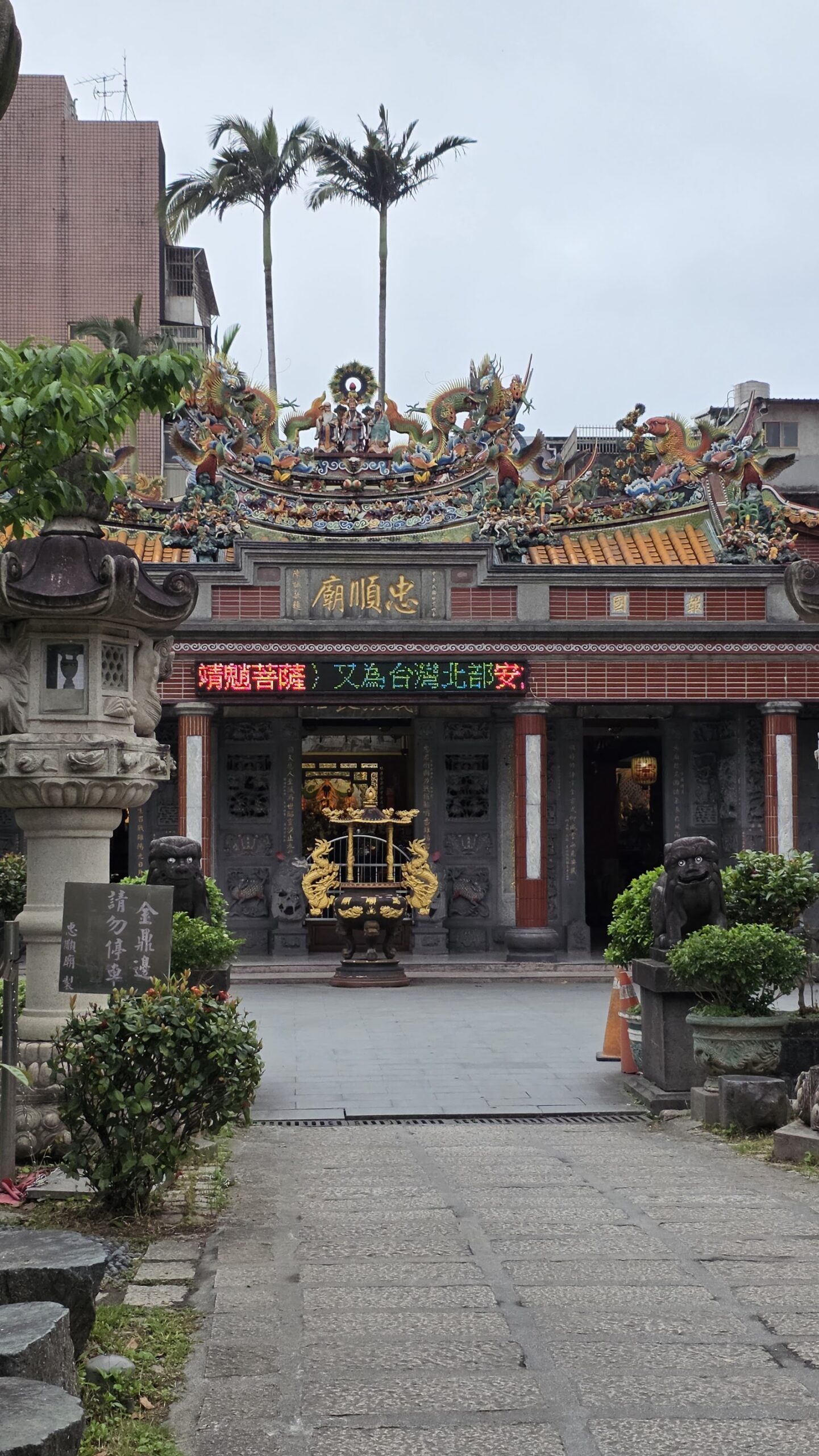 忠順廟正殿與廟埕石獅,屋脊雙龍剪黏精緻奪目