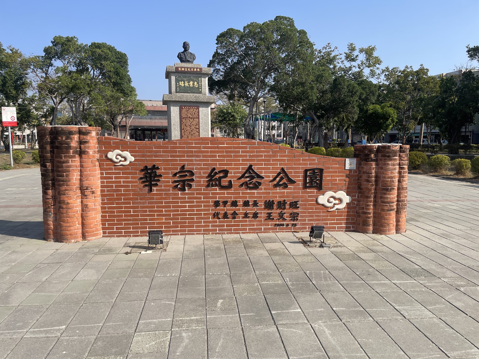 華宗紀念公園入口紅磚牆面,後方立著陳華宗先生銅像