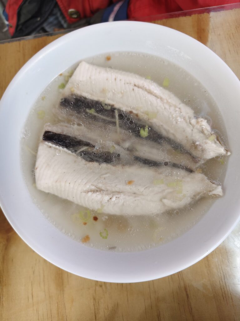 白瓷碗裝著虱目魚肚湯，魚肚鮮白完整