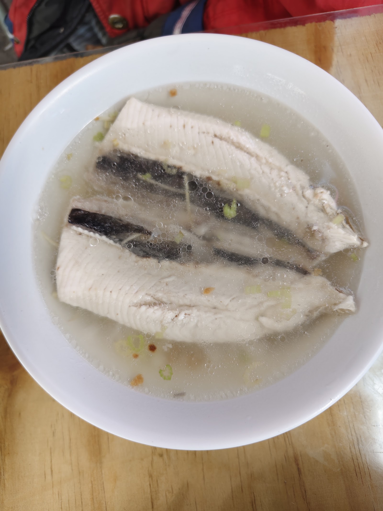 白瓷碗裝著虱目魚肚湯，魚肚鮮白完整