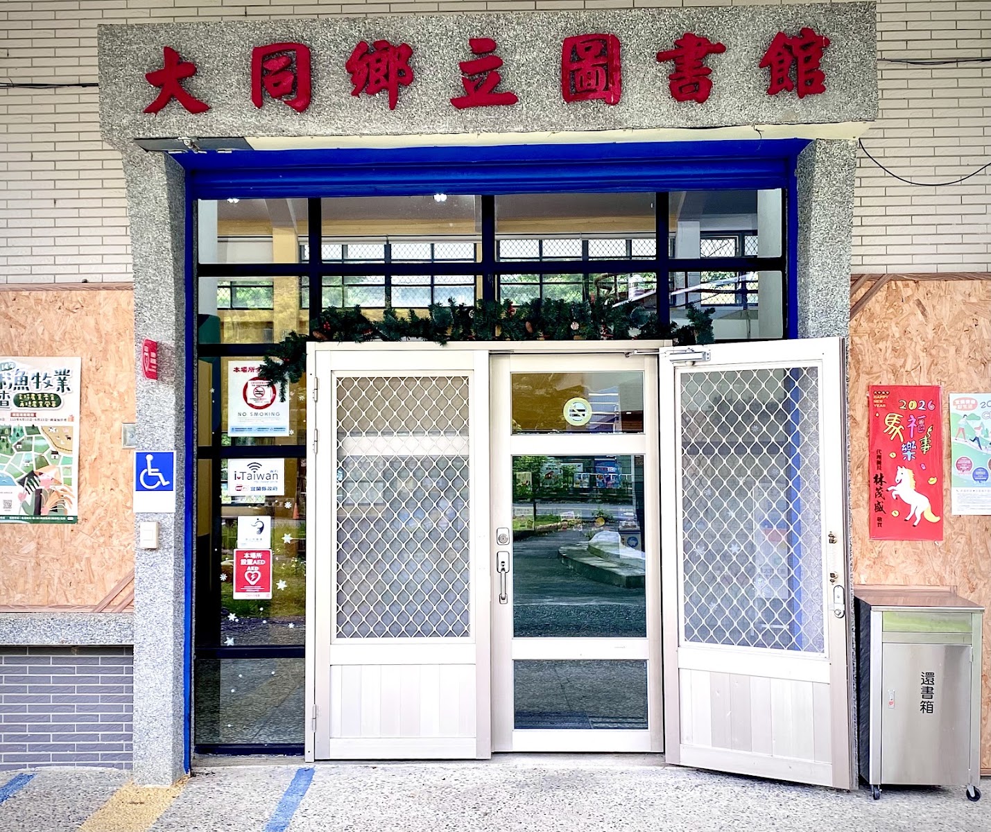 大同鄉立圖書館正門招牌特寫,紅字招牌在灰白牆面上格外醒目