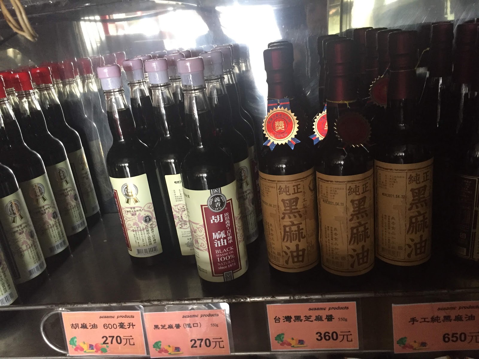 義香食品加工廠店內陳列架,黑麻油與胡麻油玻璃瓶排列整齊