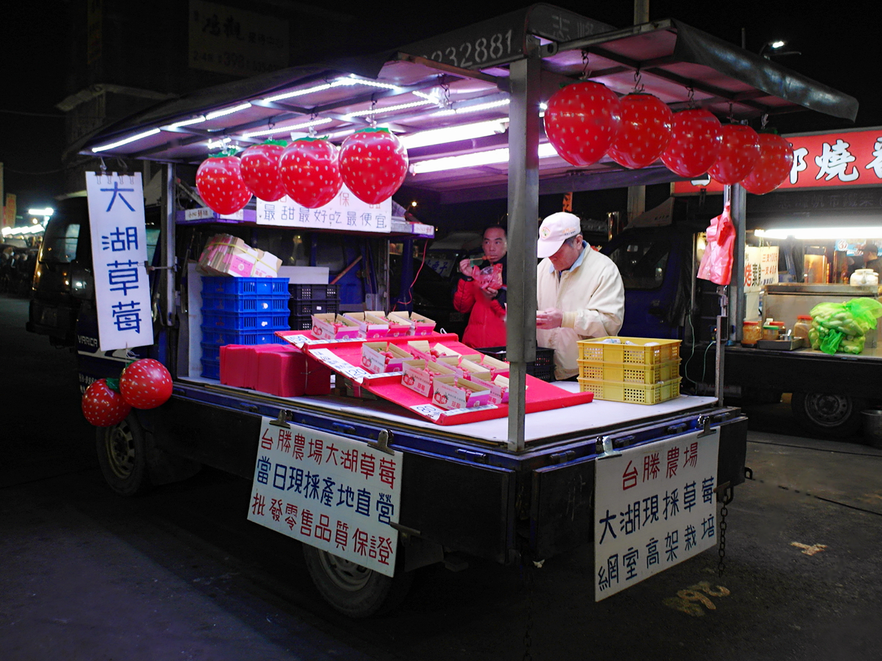 龍燈夜市-員林-夜市裡的大湖草莓水果餐車,紅色草莓氣球裝飾吸睛,攤主正忙著整理貨品