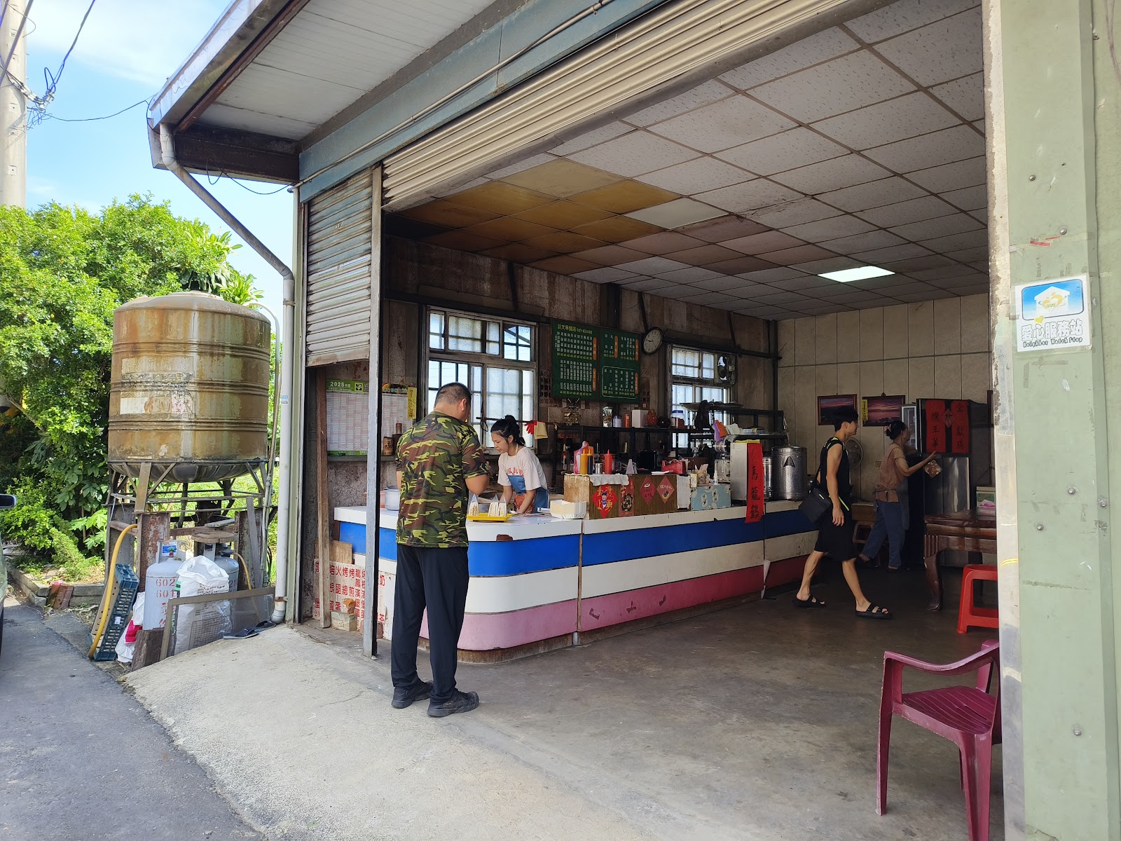 談文早餐店鐵皮屋店面外觀，老闆娘在吧檯準備餐點