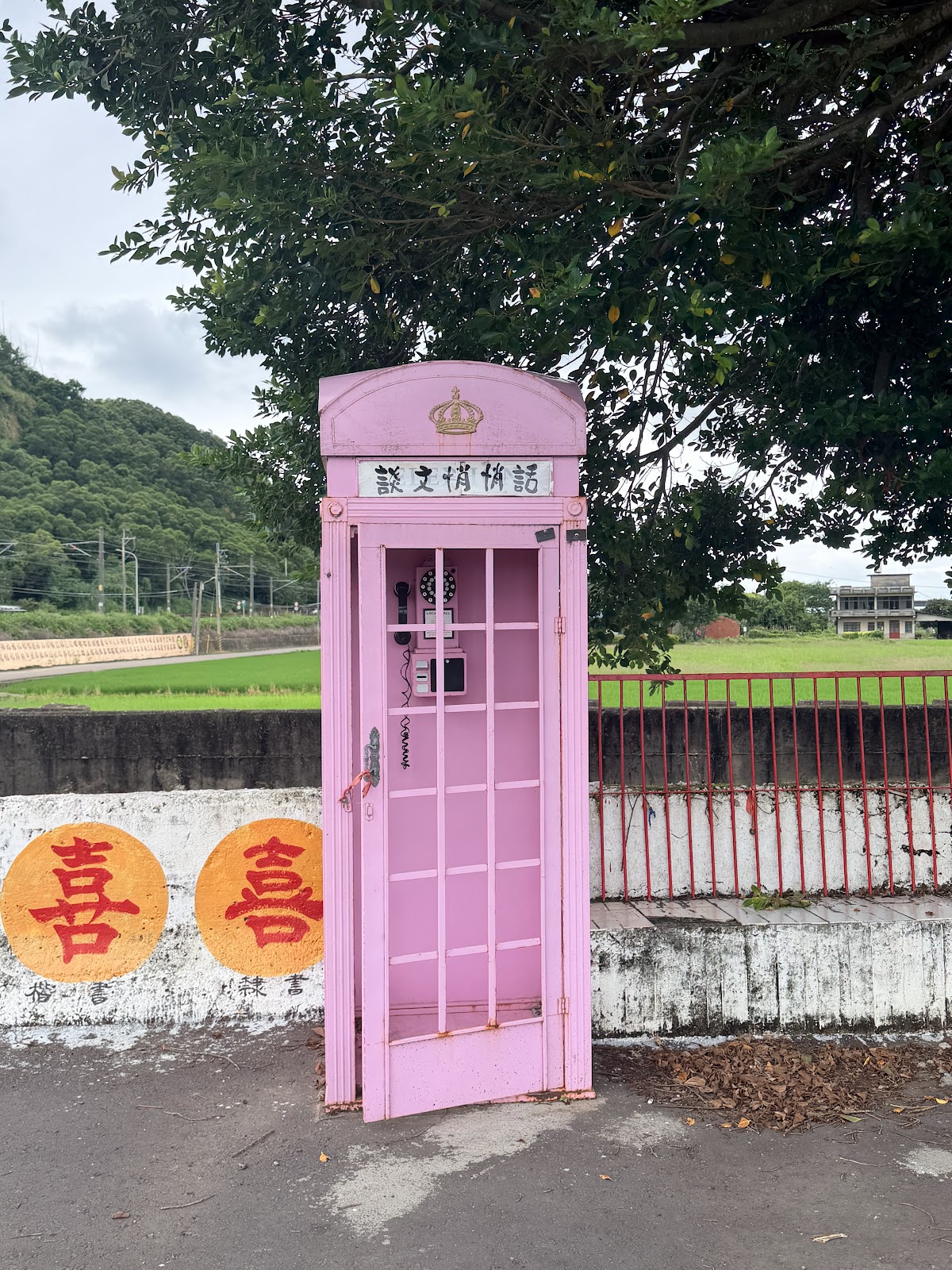 談文學讓稻路稻田旁粉紅色電話亭裝置藝術，寫著喜喜字樣