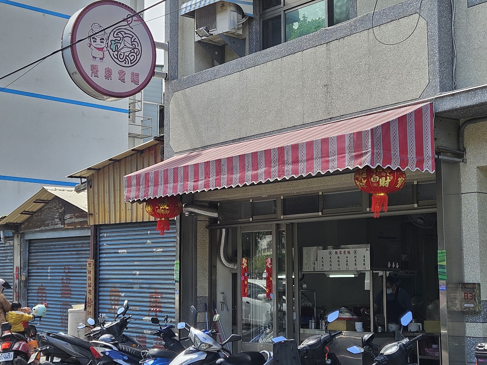 張家意麵店面招牌掛著可愛卡通人物LOGO,紅燈籠高掛