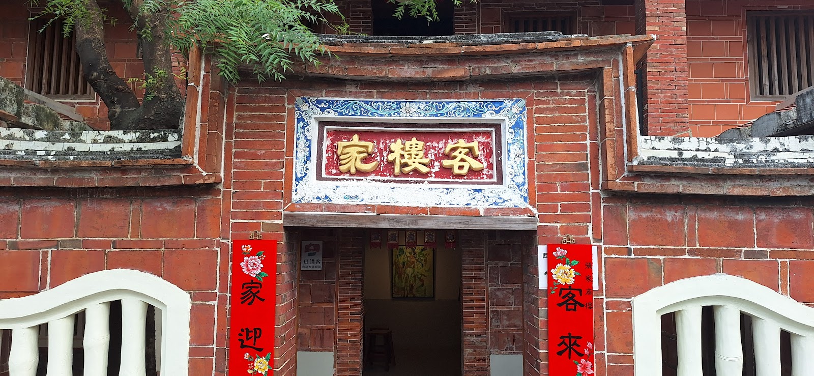 張家商樓紅磚立面特寫,彩繪匾額與對聯