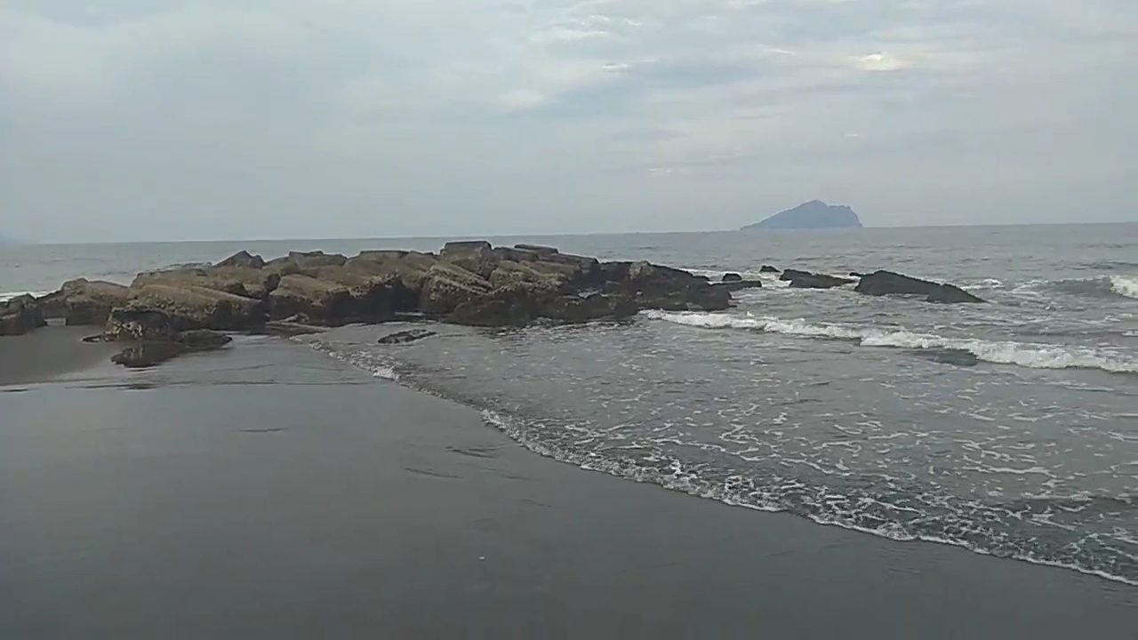 竹安溪口陰天黑沙灘與礁岩海岸