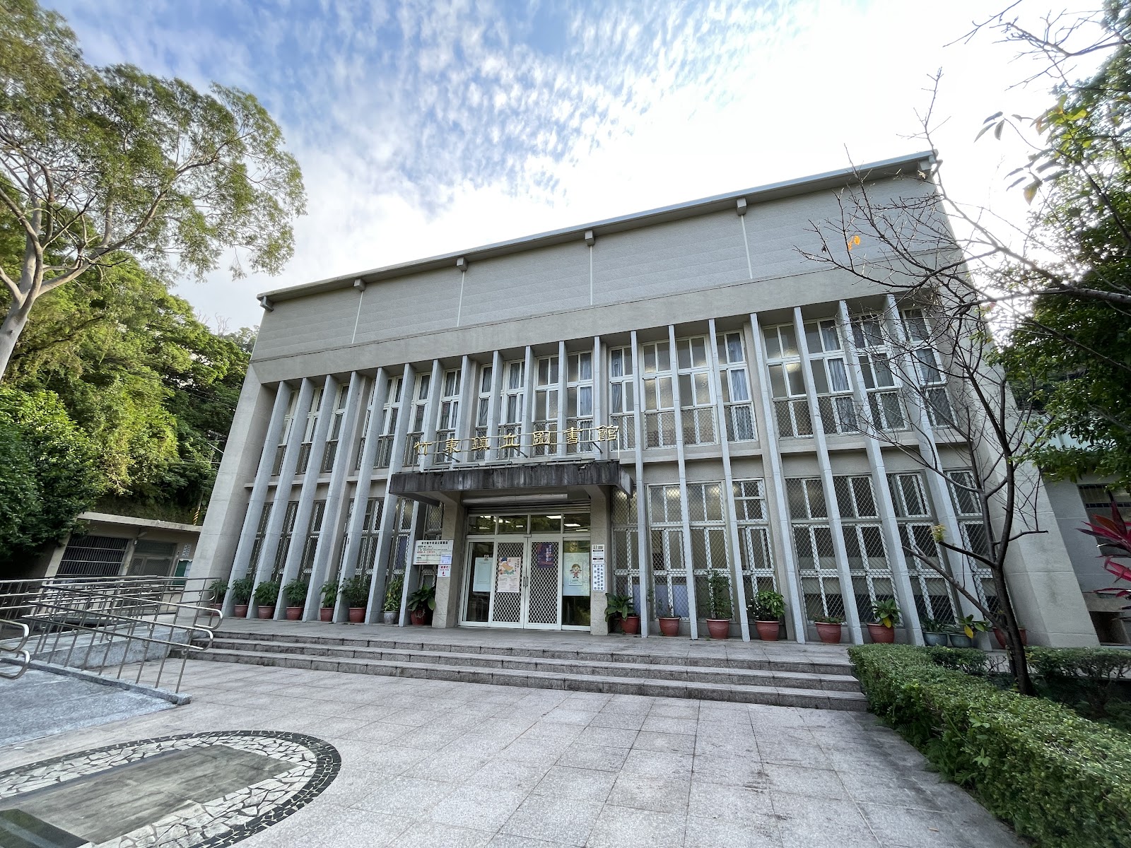 竹東鎮立圖書館建物正面廣角仰視,前庭植栽排列整齊