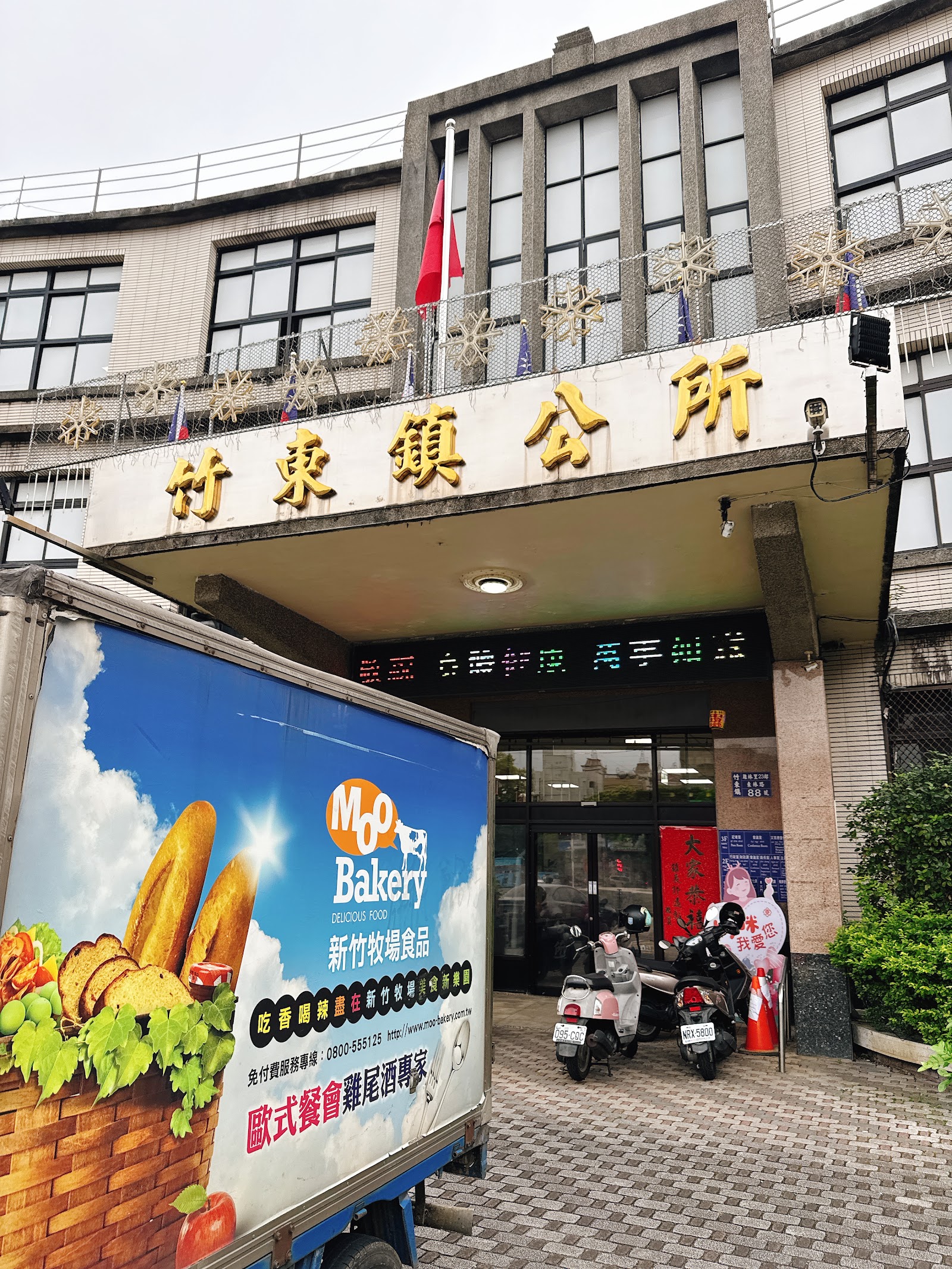 新竹縣竹東鎮公所大門口招牌與招牌下方停放的麵包宅配車